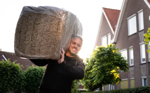 Man draagt isolatiemateriaal op zijn schouders