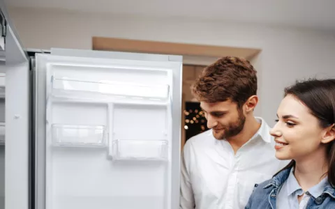 man en vrouwen zoeken koelkast uit in winkel