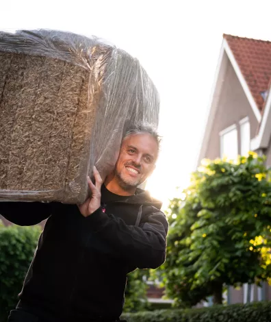 Man draagt isolatiemateriaal op zijn schouders
