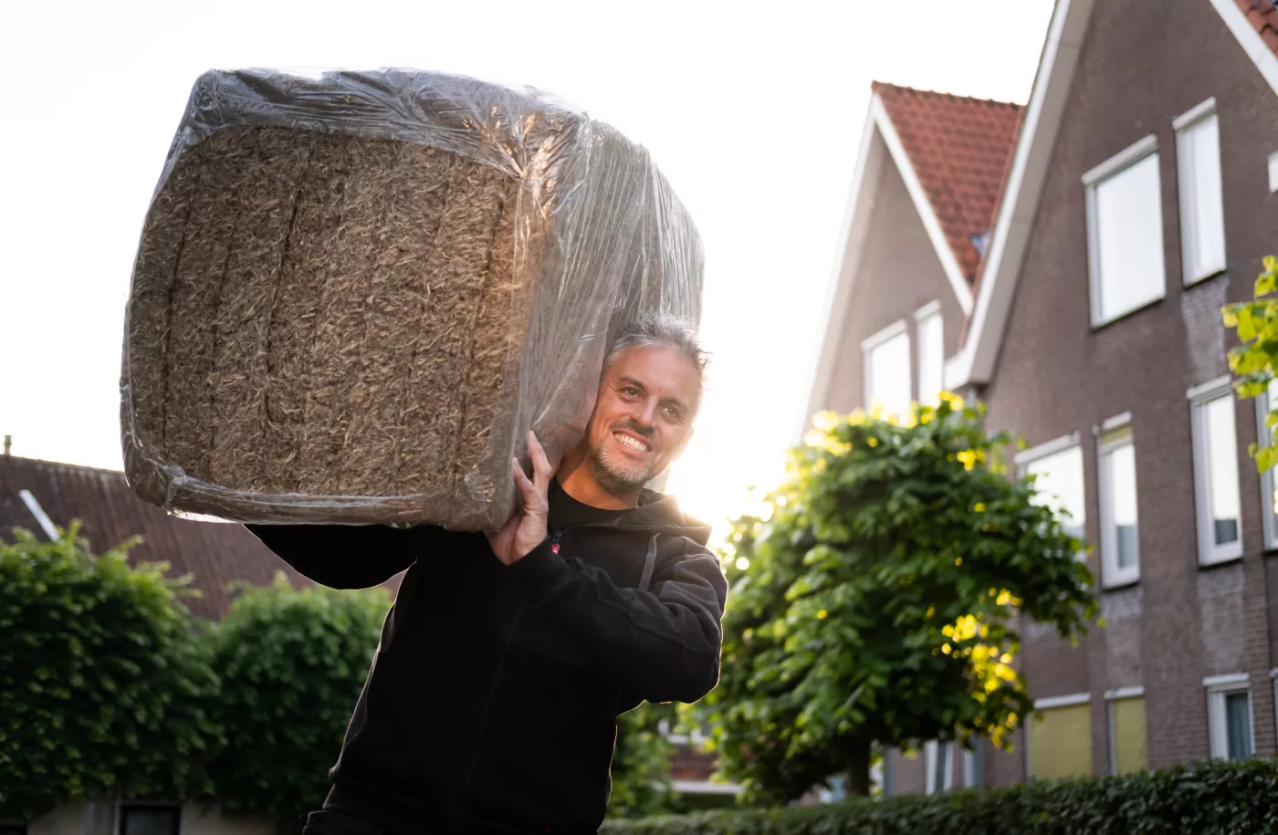 Man draagt isolatiemateriaal op zijn schouders
