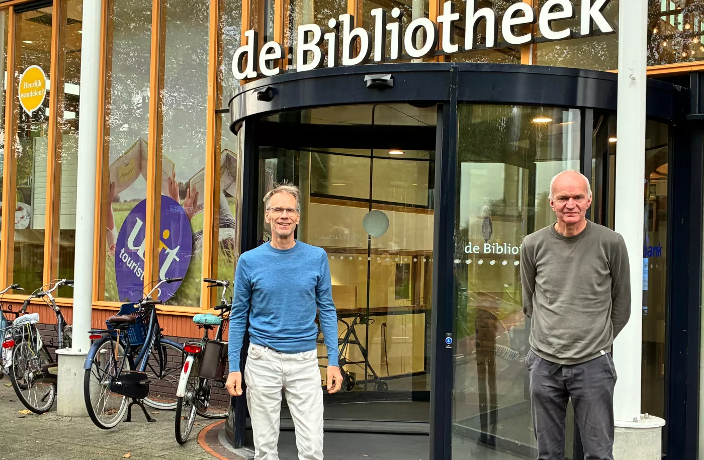 Twee mannen van het energieloket staan voor de bibliotheek 